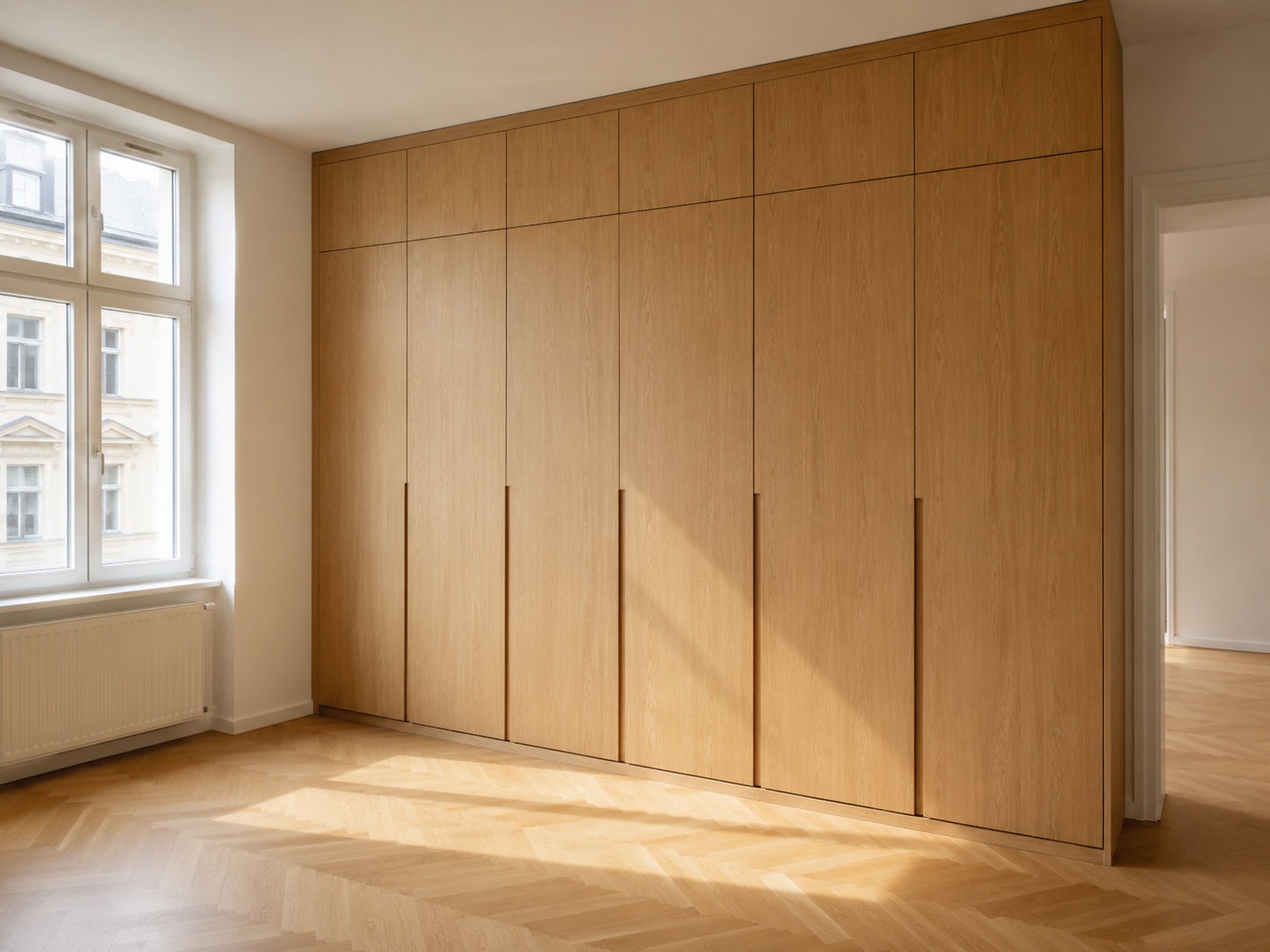 Raumhohe Schrankwand nach Maß aus hellem Holz in einer Altbauwohnung